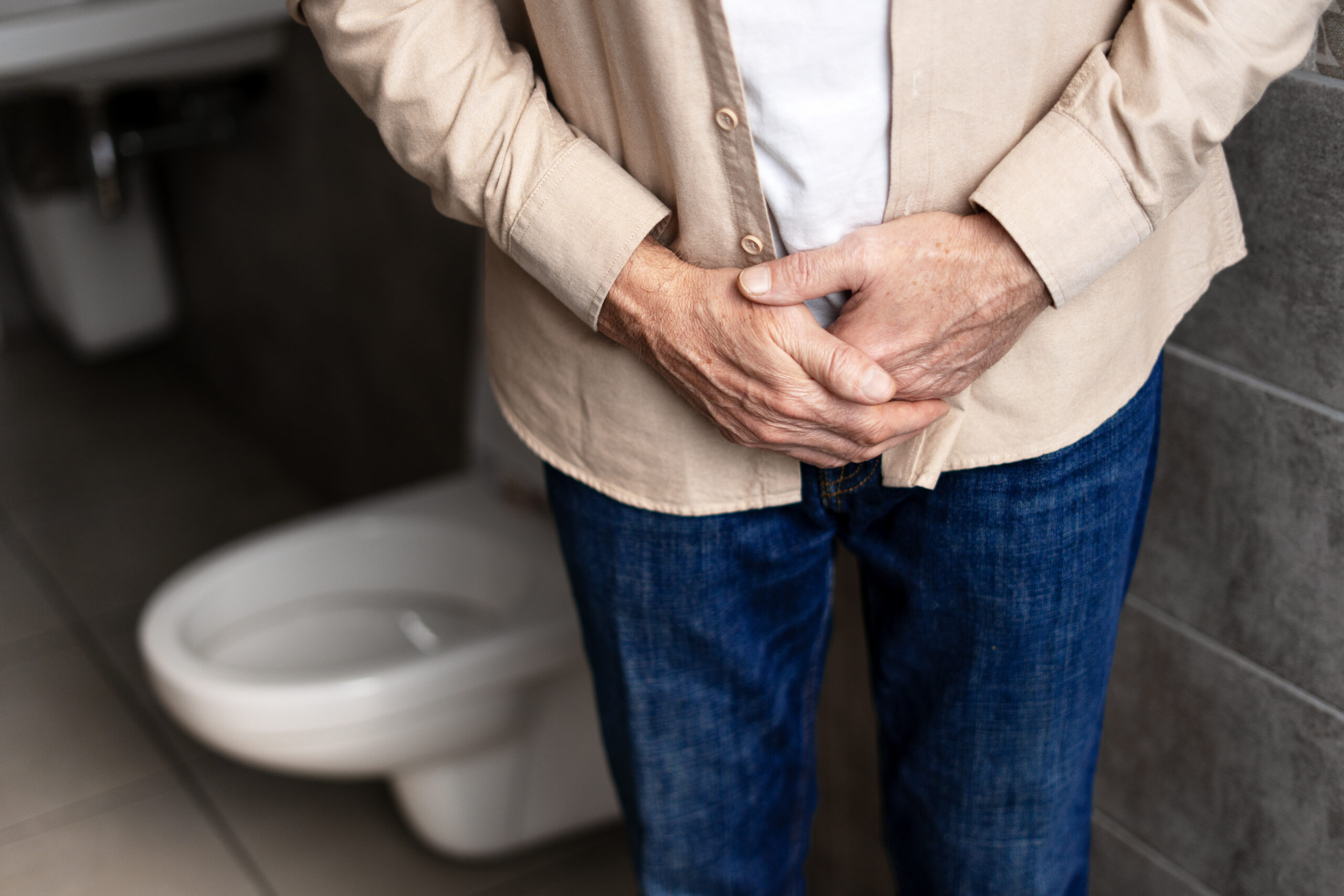 Senior man experiencing prostate problems in bathroom